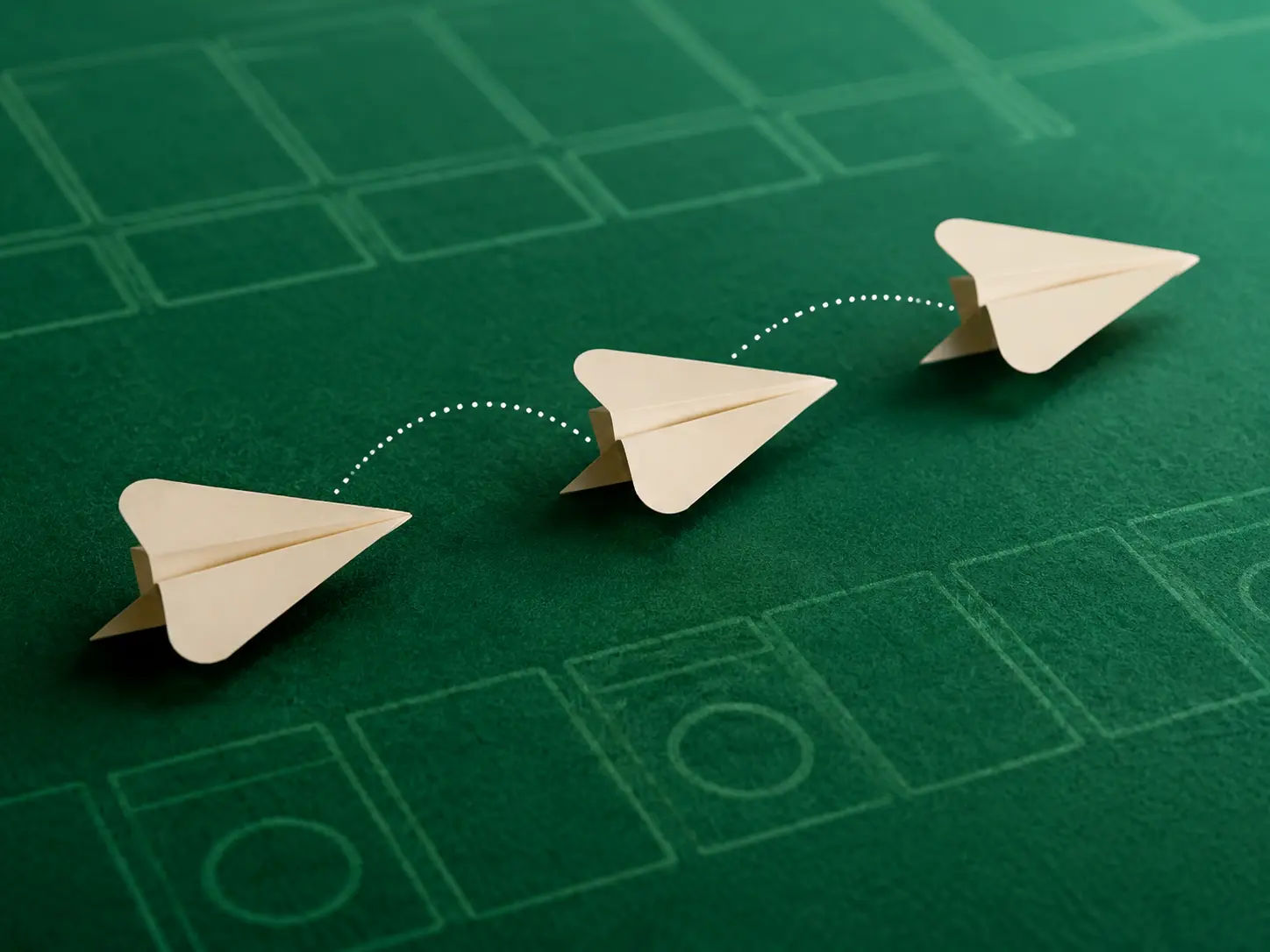 Three folded ivory paper forms moving across a green strategy grid